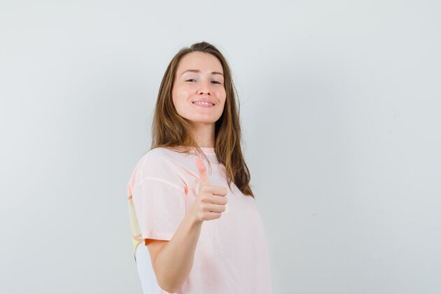 漂亮穿着粉色t恤的年轻女孩竖起大拇指 看起来很自信T恤小搞笑