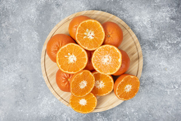 对象把新鲜多汁的橙子切片放在木盘里柑橘橙子食品
