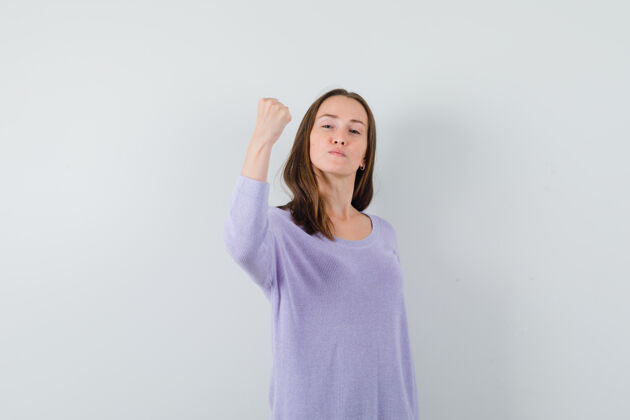 完美年轻的女性穿着淡紫色的衬衫展现她的力量 看起来很自信护理新鲜衬衫