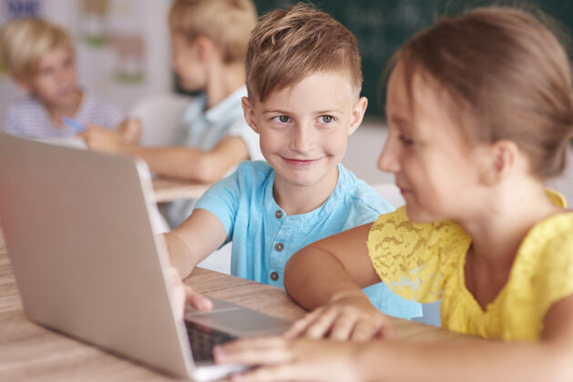 互联网女孩和男孩在教室里使用电脑小学童年流动性