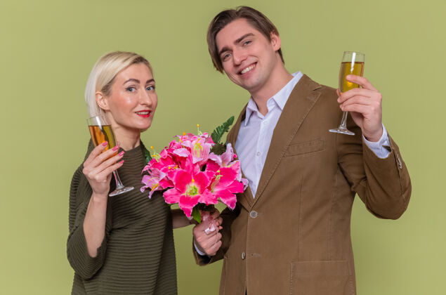 眼镜年轻漂亮的夫妇幸福的男人拿着花束 女人拿着香槟酒杯男人夫妇年轻
