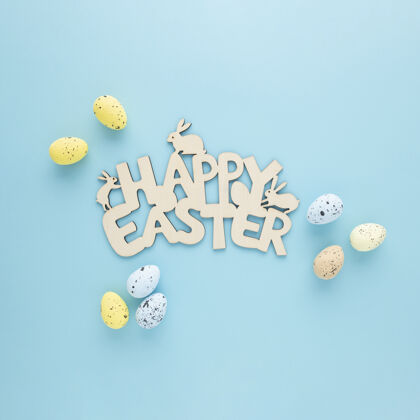 顶视图复活节快乐木制标志 蓝色背景上有彩蛋庆祝彩蛋复活节