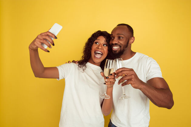 男人一起自拍一对快乐的非洲裔美国夫妇被隔离在黄色的墙上人类情感的概念 面部表情 爱情 关系 浪漫的节日女人表情男朋友