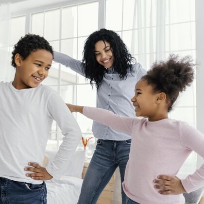 娱乐母亲和孩子们在家跳舞的正面图广场乐趣兄弟姐妹