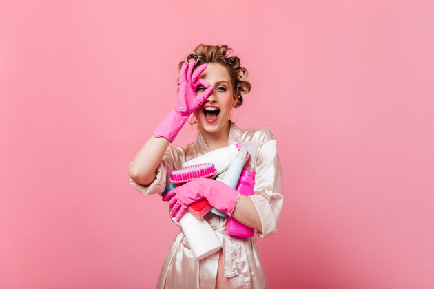 快乐穿着粉红色长袍的美女显示标志ok并拿着洗涤剂脸衣服年轻
