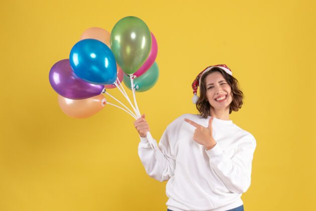 女人正面图：手持黄色气球的年轻女子气球正面派对