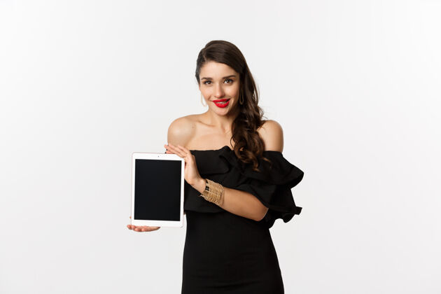 模型网上购物的概念诱惑美丽的女人在黑色礼服显示数字平板电脑屏幕 站在白色背景复制空间服装时尚女人