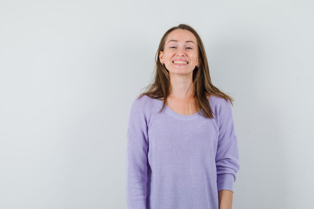 性感年轻的女人穿着淡紫色的衬衫微笑着 看起来很快乐姿势头发时尚