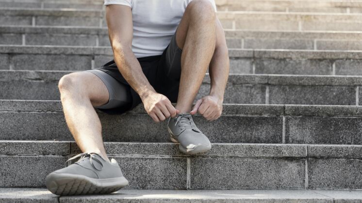 水平男人在运动前系鞋带的正面图保持健康健身活动