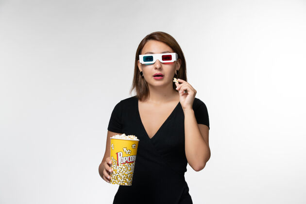太阳镜正面图戴着d型太阳镜拿着爆米花的年轻女性在白色表面看电影看抱着电影