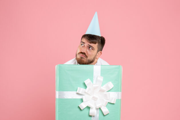 庆祝正面图年轻男性站在礼物盒内强调粉色睡衣派对照片情感睡眠圣诞站立里面礼物