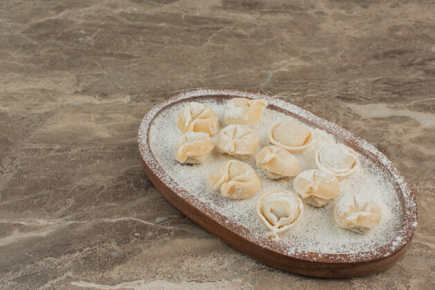 食物生饺子在木板上加面粉面粉生的好吃