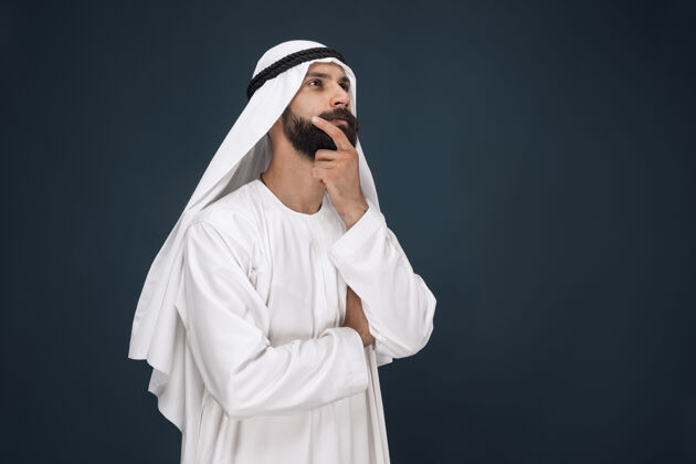 伊斯兰深蓝色工作室墙上的阿拉伯沙特商人半身像手势胡须男性
