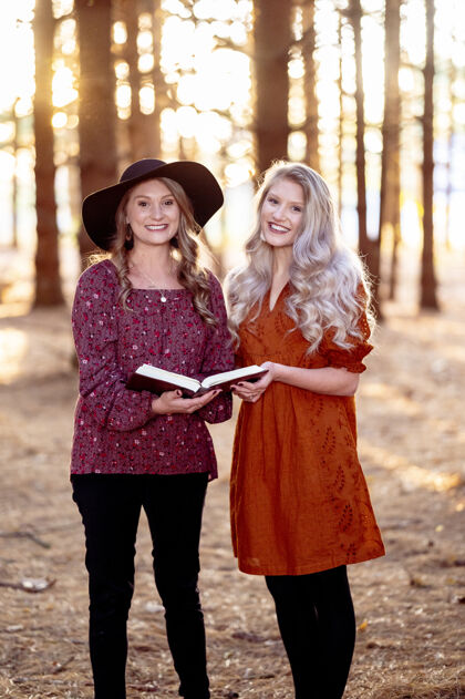 读者两个年轻女性在森林里和一本书合影的镜头 秋天的心情心情年轻学习