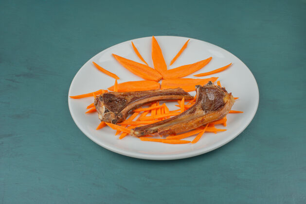 盘子白板烤羊排配胡萝卜片食物顶视图排骨