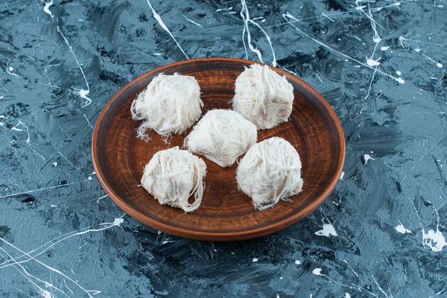美味传统的土耳其棉花糖放在木制盘子上 蓝色背景传统棉花糖美味