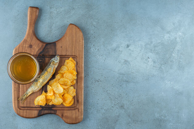 美味薯条 鱼和一杯啤酒放在木板上 大理石背景上烤薯条美味