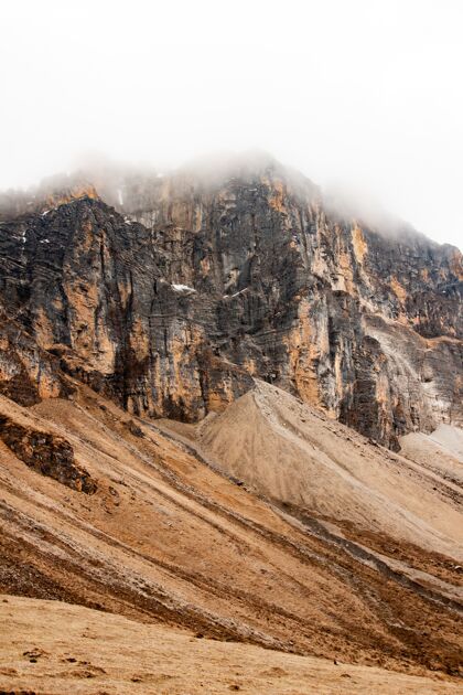 雪不丹喜马拉雅山云层下的一座山的垂直拍摄垂直徒步旅行冰川