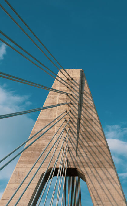 太阳蓝天下一座桥的垂直镜头蓝色自然城市