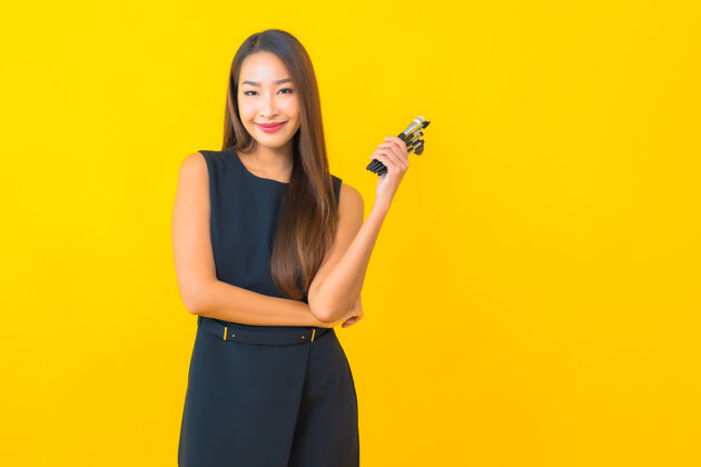 设备在黄色背景上用化妆刷描绘美丽的亚洲女商人博客刷子订阅