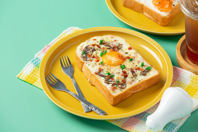 奶油烤面包 配上炒鸡蛋和奶油奶酪 背景是柔和的绿色菠菜食谱早餐