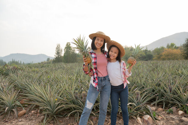 年轻亚洲女农民在农场看菠萝生长 农业产业观念农场美丽有机