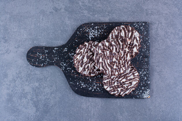 甜石头上放着一块黑色的甜饼木板自制软巧克力