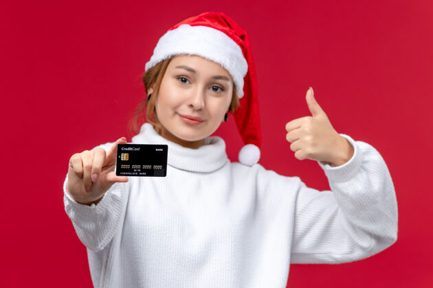 男性前视图年轻女性与红色背景上的银行卡合影青年圣诞节人