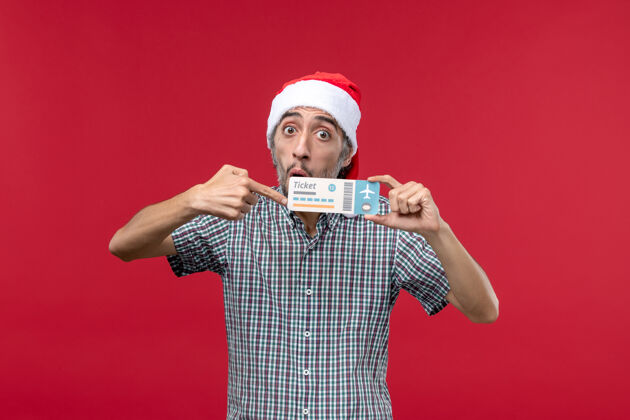 成人正面图红色背景下手持机票的年轻男性圣诞飞机表情