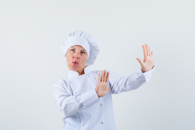 年轻女厨师穿着白色制服为自己辩护 看上去很焦虑人脸嘴唇
