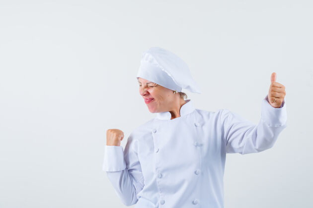 显示一位身穿白色制服的女厨师一边竖起大拇指 一边摆出胜利者的姿态 看上去很欢快粉色脸嘴唇