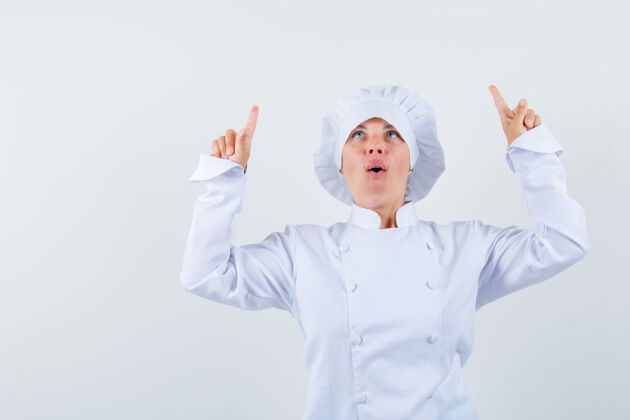 表情一位身穿白色制服的女厨师指着头 看上去充满希望希望女人女士