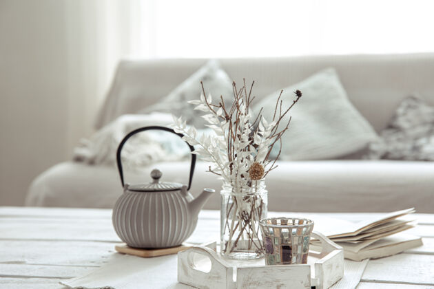 斯堪的纳维亚茶壶和装饰细节在客厅的桌子上 在一个hygge风格装饰室内组成