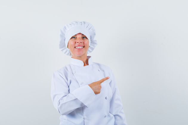 喜悦身着白色制服的女厨师指着右上角 看上去很自信权利魅力年轻