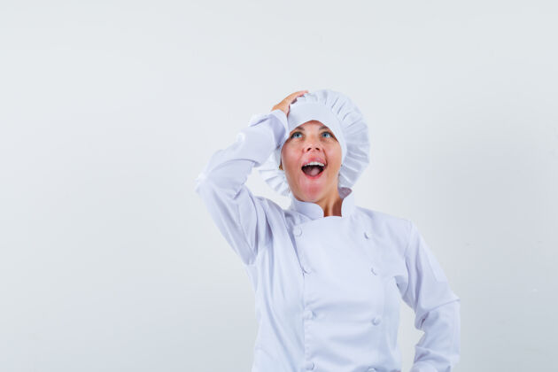 好看一位身穿白色制服的女厨师 手举在头上 看上去很惊讶卷发喜悦脸