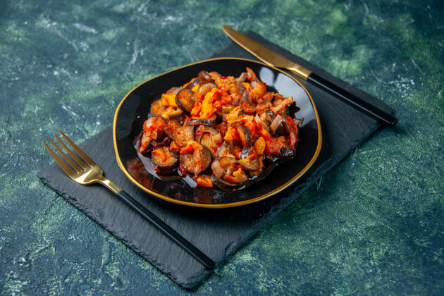 盘子前视图煮熟的酱汁茄子在黑暗的背景上黑色的盘子里晚餐深色黑色