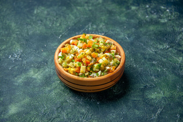 食物前视图蔬菜沙拉从煮熟的蔬菜混合在黑暗背景的圆形盘子里背景晚餐混合