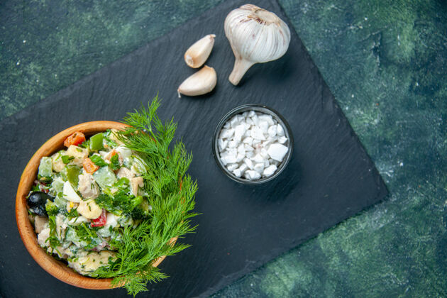 菜肴在深蓝色背景上俯瞰蔬菜沙拉和蔬菜和大蒜蔬菜蛋黄酱绿色