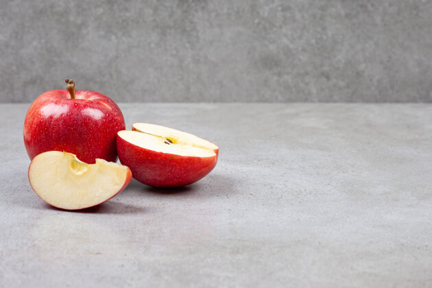 甜点新鲜的有机苹果整个或切片的红苹果放在灰色的桌子上一半顶部苹果