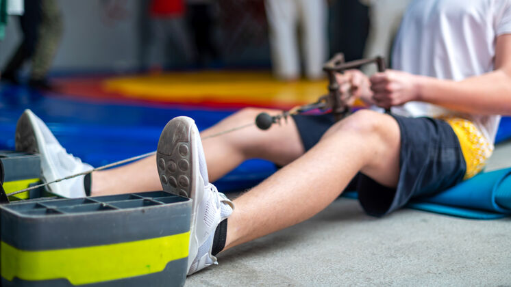 普拉提一个男人在健身房的地板上用模拟器做运动肌肉年轻器械