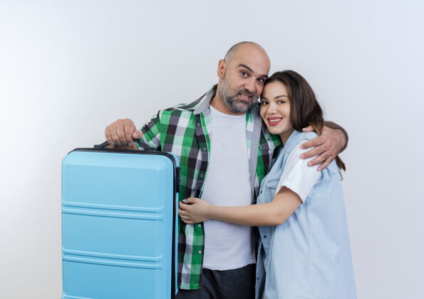 手提箱快乐的成人旅行家夫妇男人拿着手提箱互相拥抱看着男人成人每一个