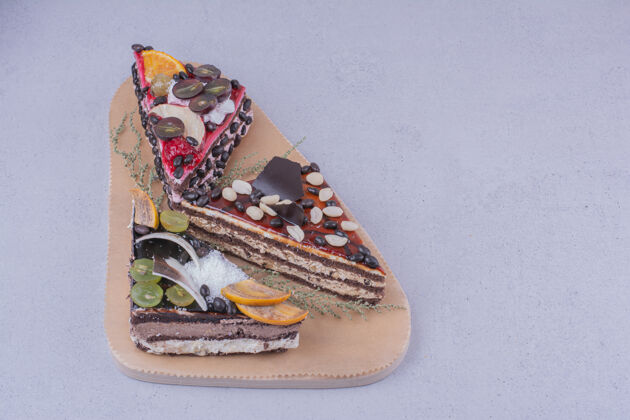 香草三角形状的巧克力蛋糕片与坚果和水果放在一个木盘上地壳健康脂肪