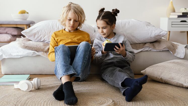 房子兄弟姐妹玩手机和平板电脑小玩意女孩兄弟姐妹