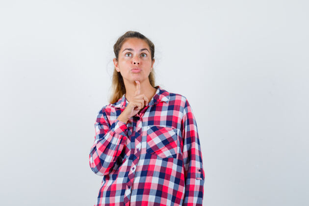 深色照片中的年轻女士穿着格子衬衫 手指托着下巴 面带沉思自然衬衫视图