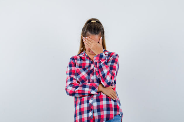 衬衫年轻女子穿着休闲衬衫 手贴在脸上 看起来很沮丧的正面照片一个时尚前面