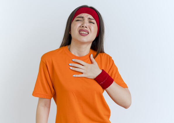 腕带戴着头带和腕带 手放在胸前的年轻运动女性疼年轻戴