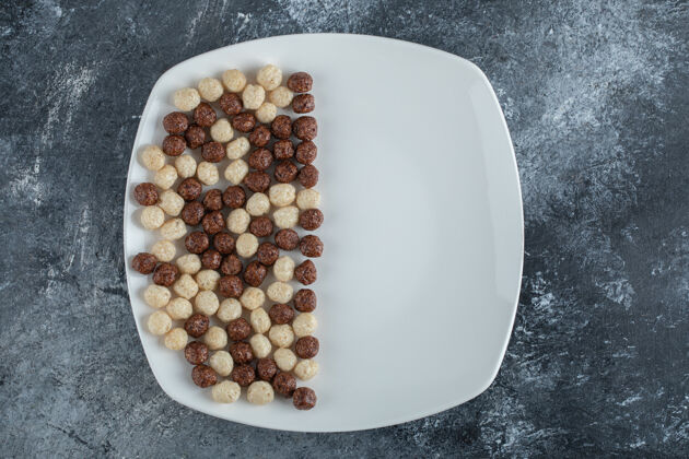 可可白盘子上的巧克力和麦球谷类圆形谷物