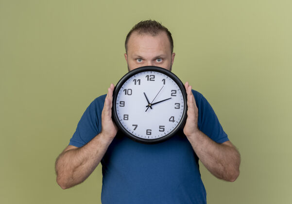 橄榄成年斯拉夫人拿着钟从钟后面看成人时间时钟