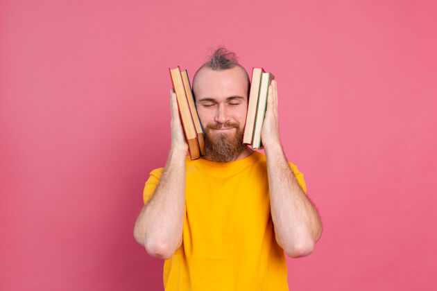 工人满脸笑容的成人休闲装 留着胡子的家伙拥抱着自己最喜欢的书 把自己孤立在粉色上知识人教育