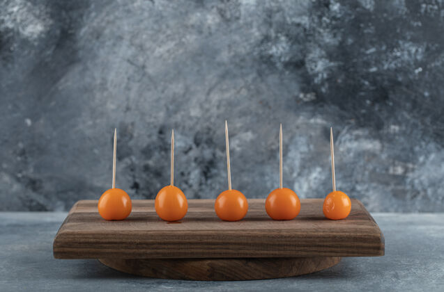 生的橘子西红柿和木棍放在木板上健康蔬菜多汁